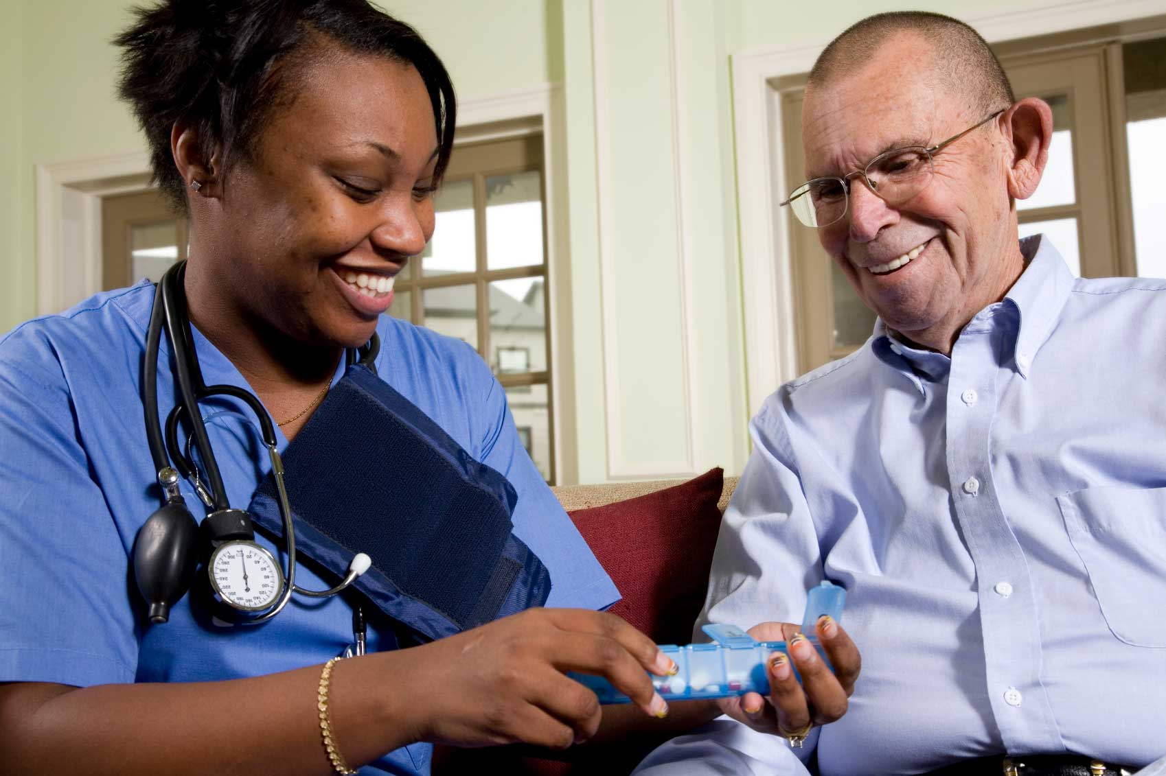 female caregiver administrating medication to senior male patient